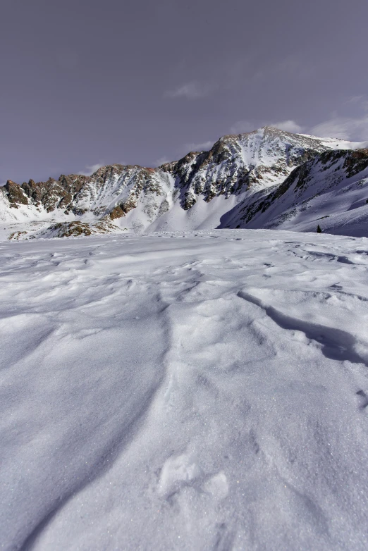 a snow covered mountain next to a snowy slope