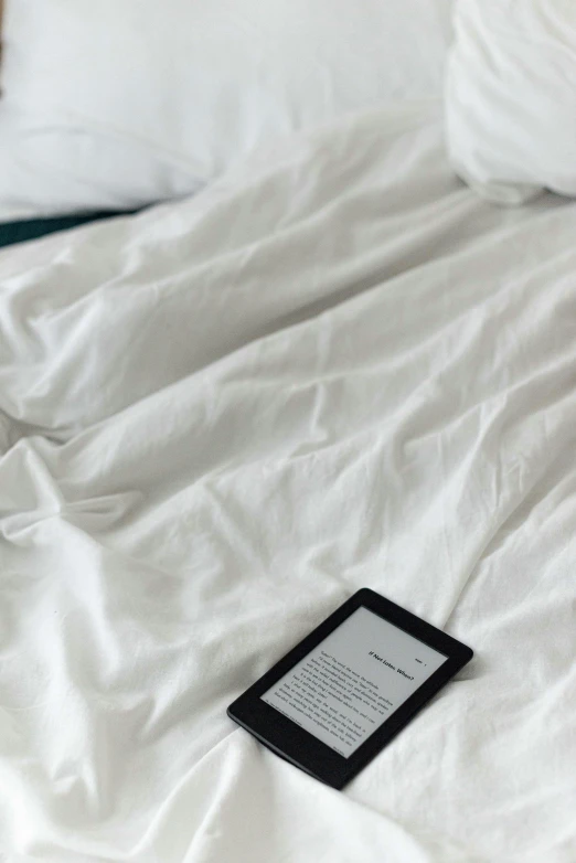 a book laying on the bed next to a pillow