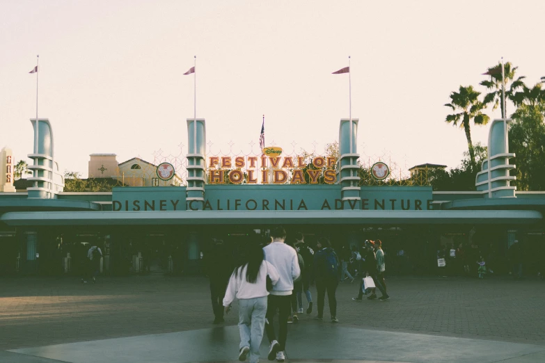 people standing outside of a sign at disneyland california