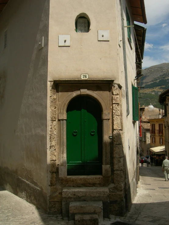 a green door on a small building that has steps up to it