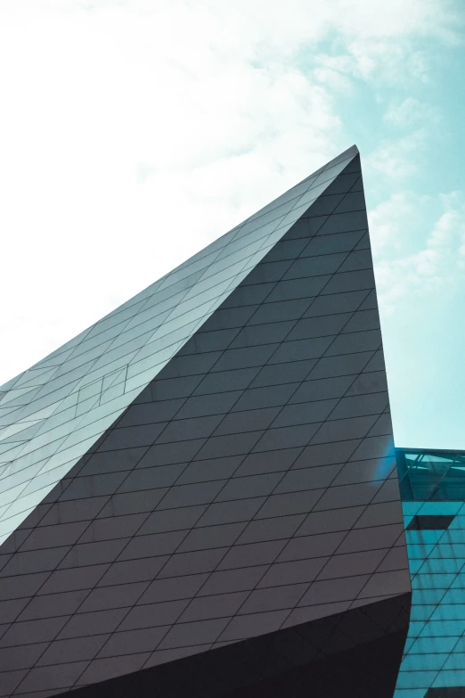 a large triangular shaped building is sitting under a blue sky