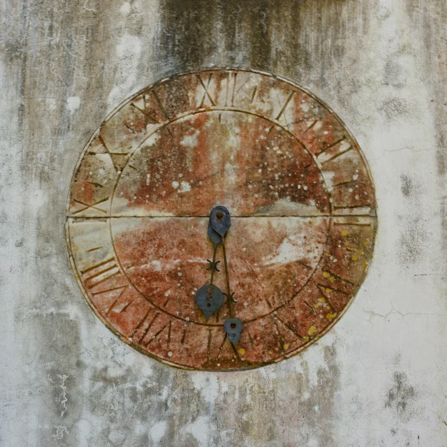 a rusty, dirty roman numeral clock on an old building