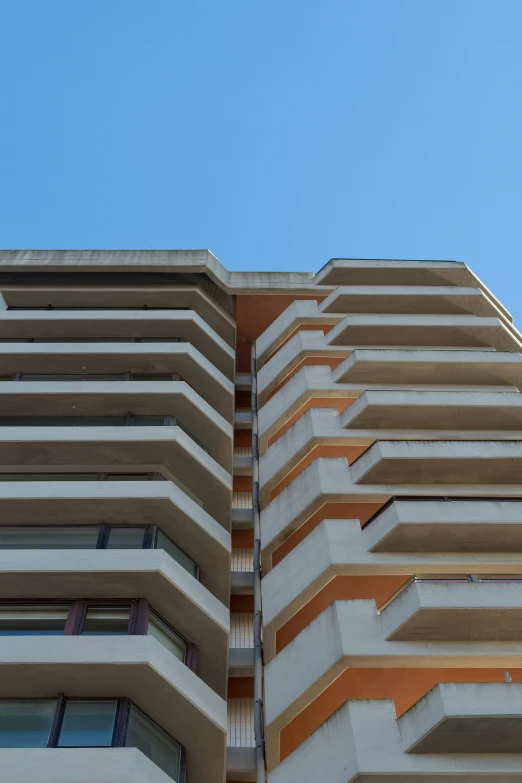 tall multistory building with balconies in the sun