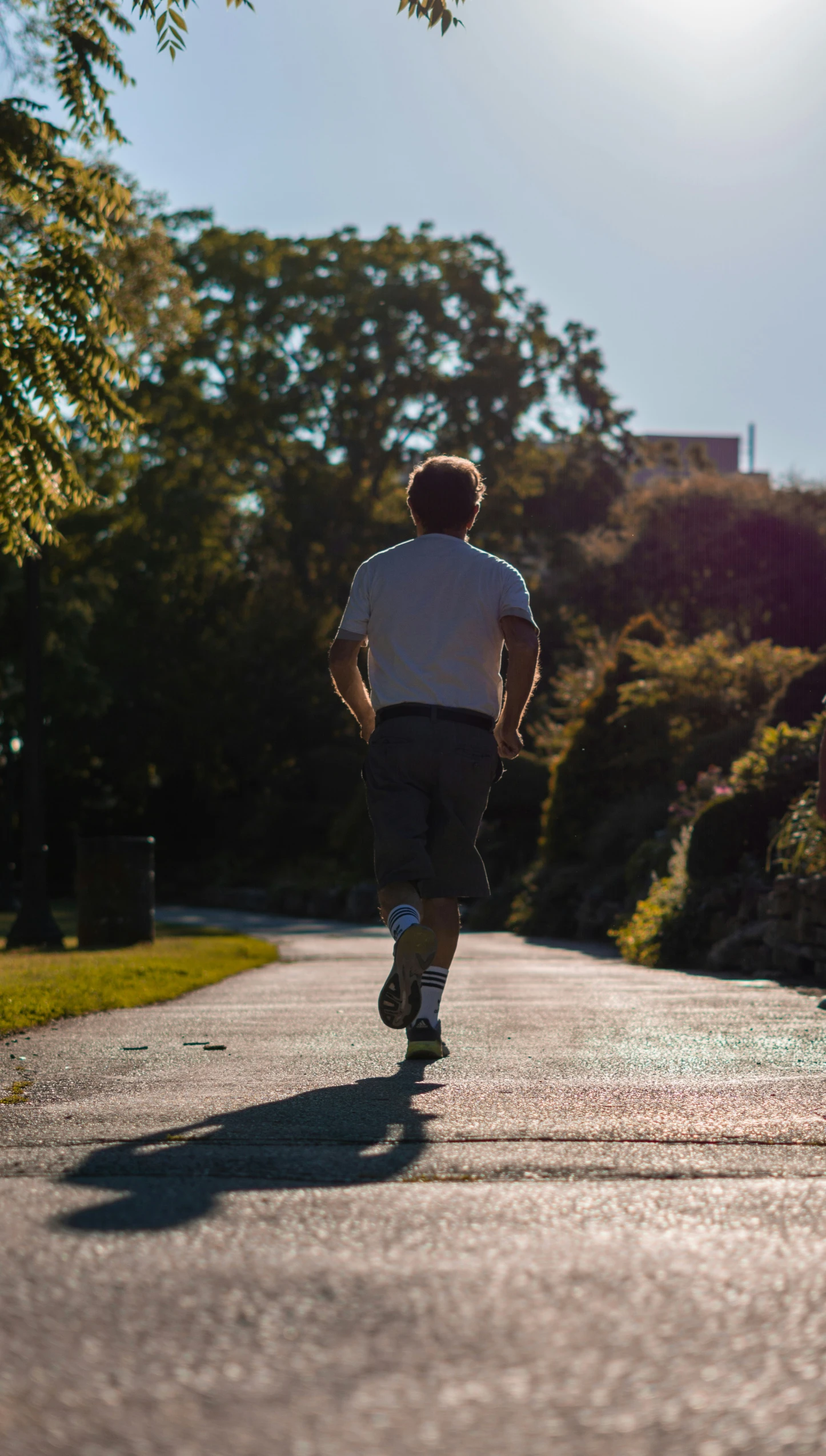 a man in white shirt skateboarding down street