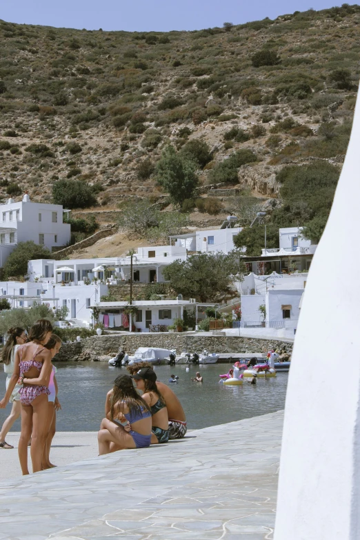 several young people in bikinis are sitting on the beach