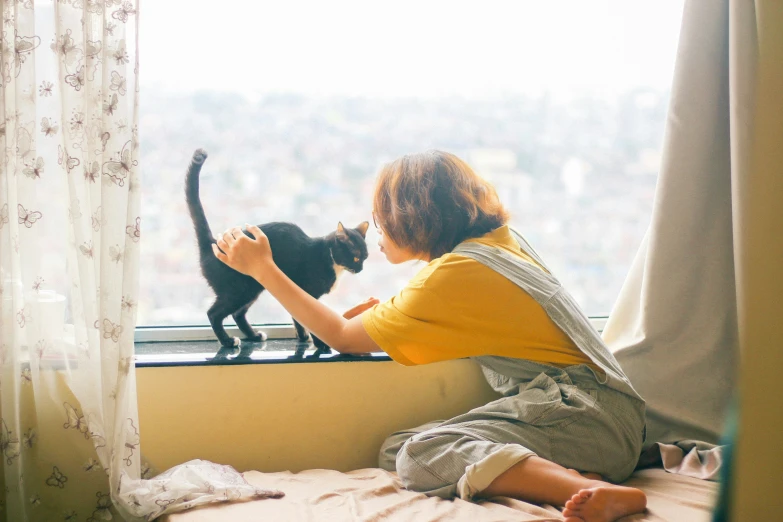 a person and a cat sitting by the window