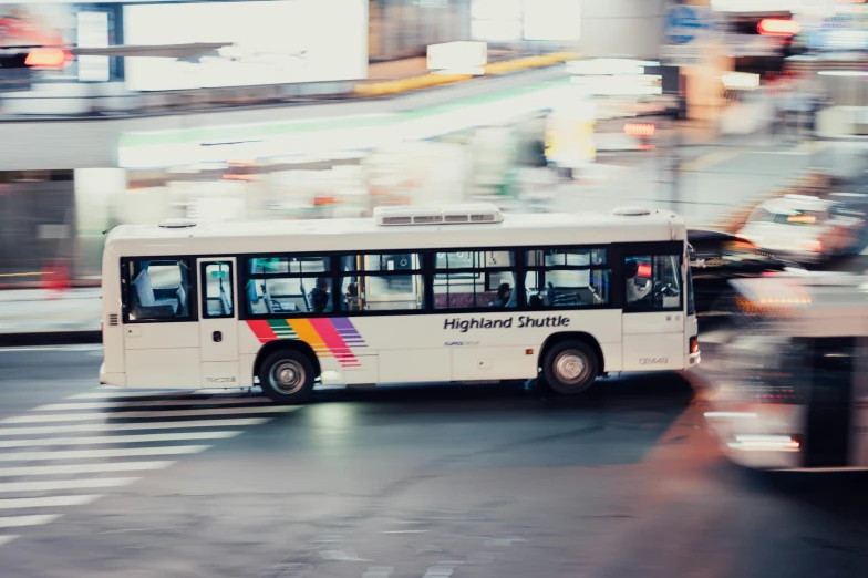 the white bus is riding down the road