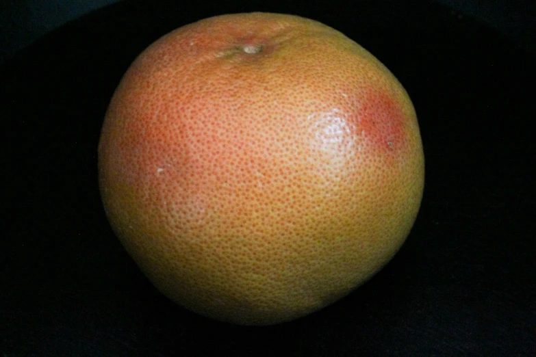 closeup view of an orange with black background