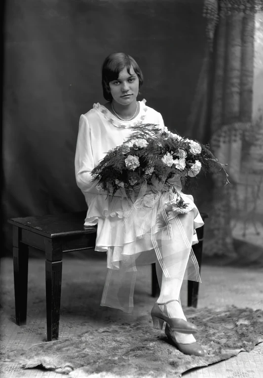 a woman holding flowers is sitting on a bench