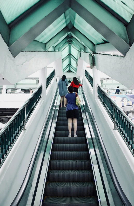 an escalator with two people going down it