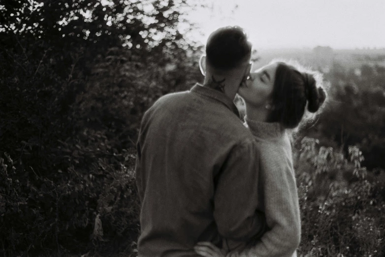 an old po of a man and a woman kissing in the forest