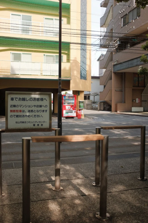 a bus stop with a large yellow building