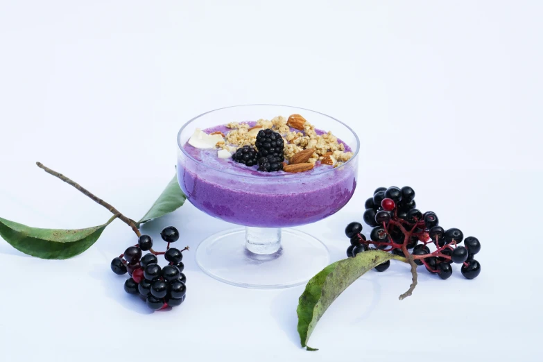 a drink sits on a white surface with some berries