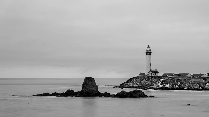 a very pretty lighthouse next to a big rock