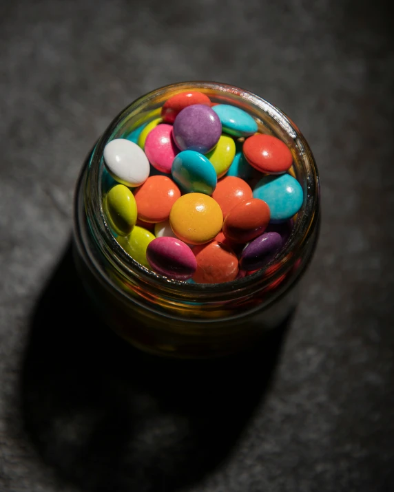 a glass jar filled with colorful candy and lollies