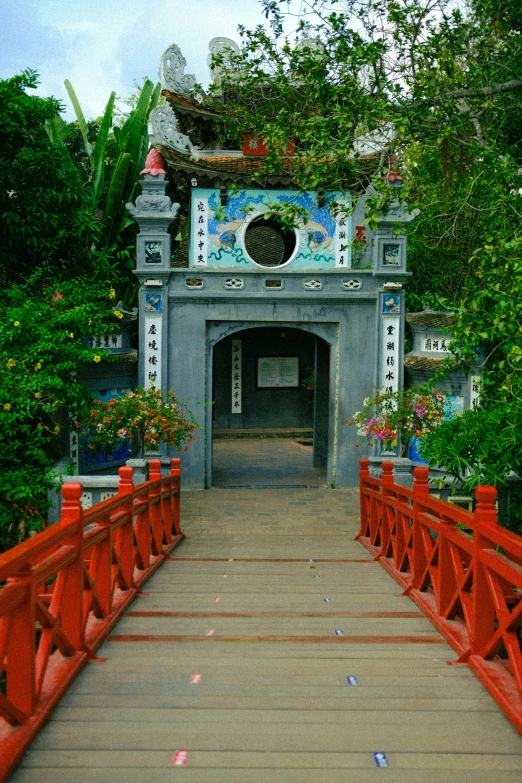 a small bridge made of wood with an oriental gate in the middle