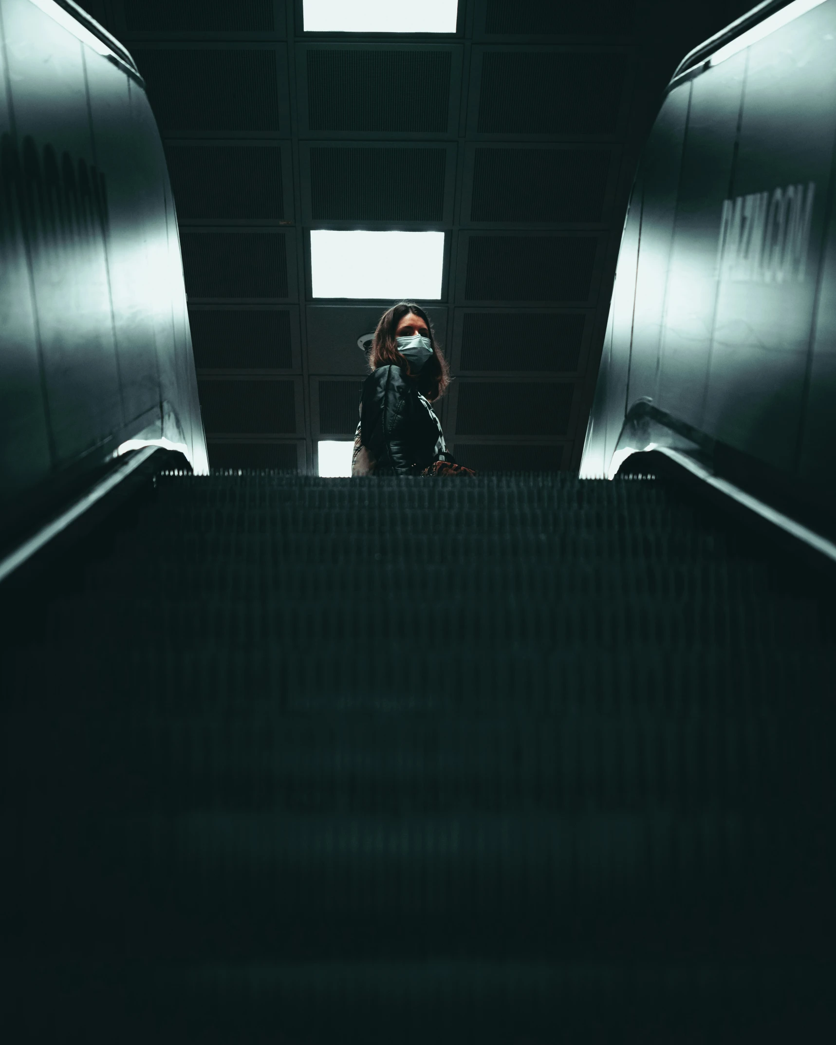 a woman is sitting on an escalator and taking a po