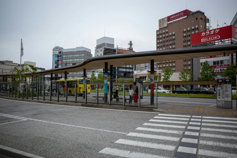 a bus stop on the street corner next to a few buildings