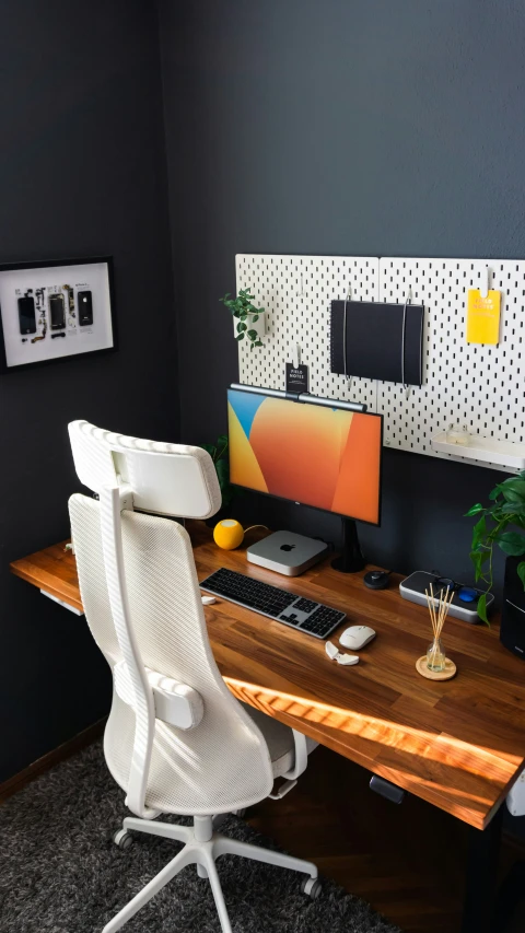 an office with a computer, keyboard and some plants