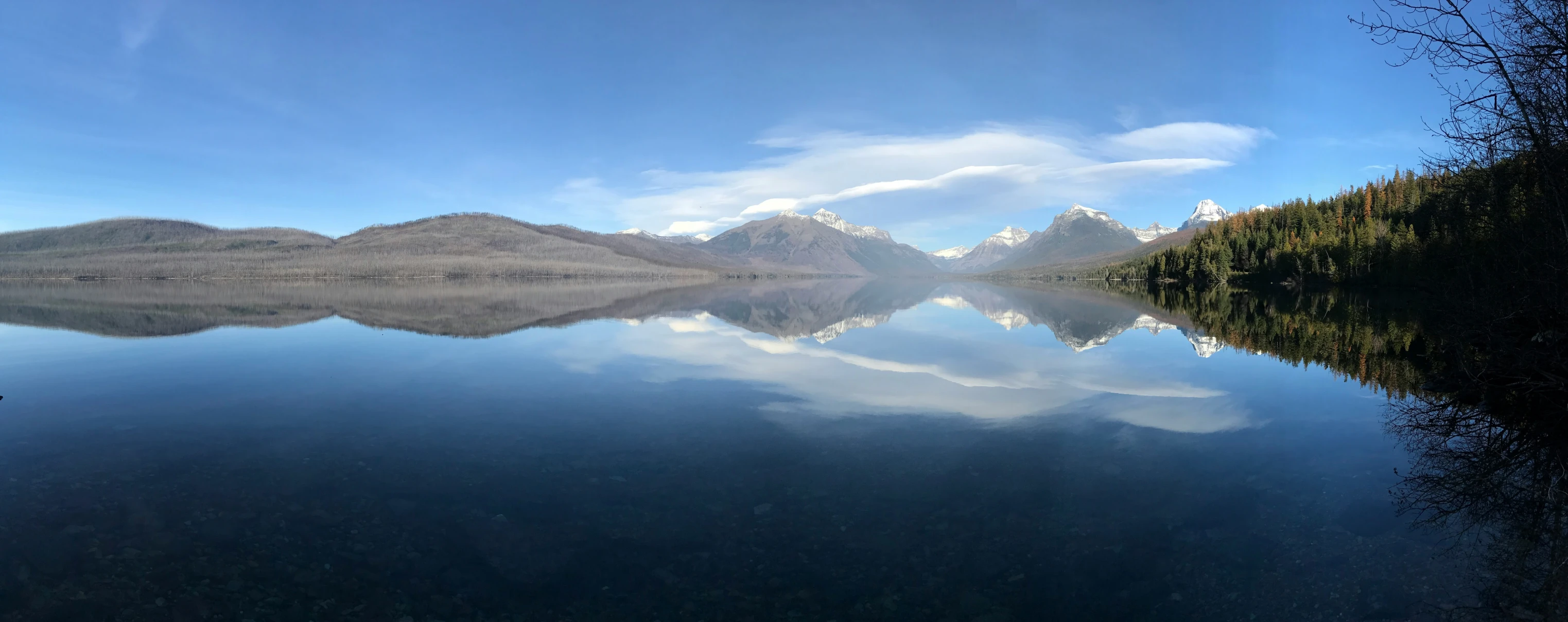 a small body of water with mountains in the background