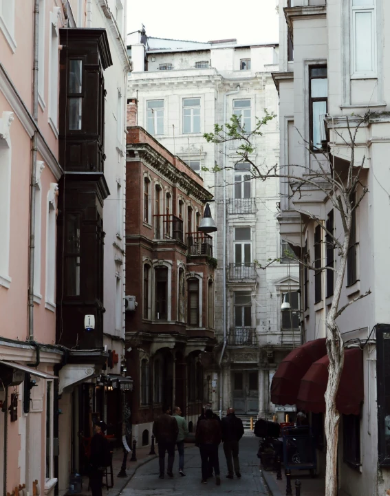 several people walking on the street through an old city