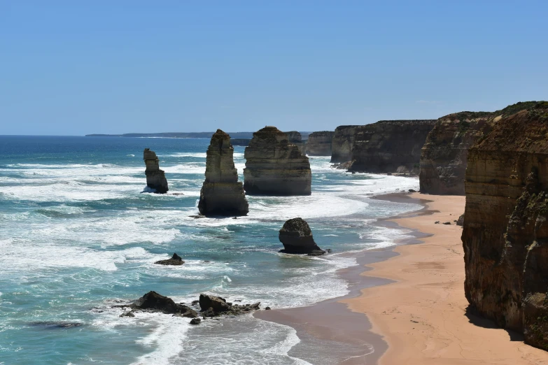 the ocean with three very tall rocks sticking out of it