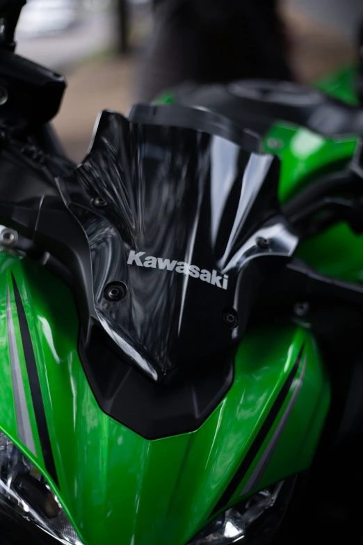 the view of a green motorcycle with a black windshield