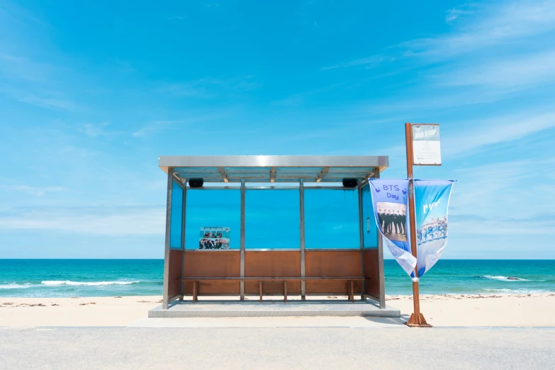 an outdoor bus stop at the beach next to the ocean