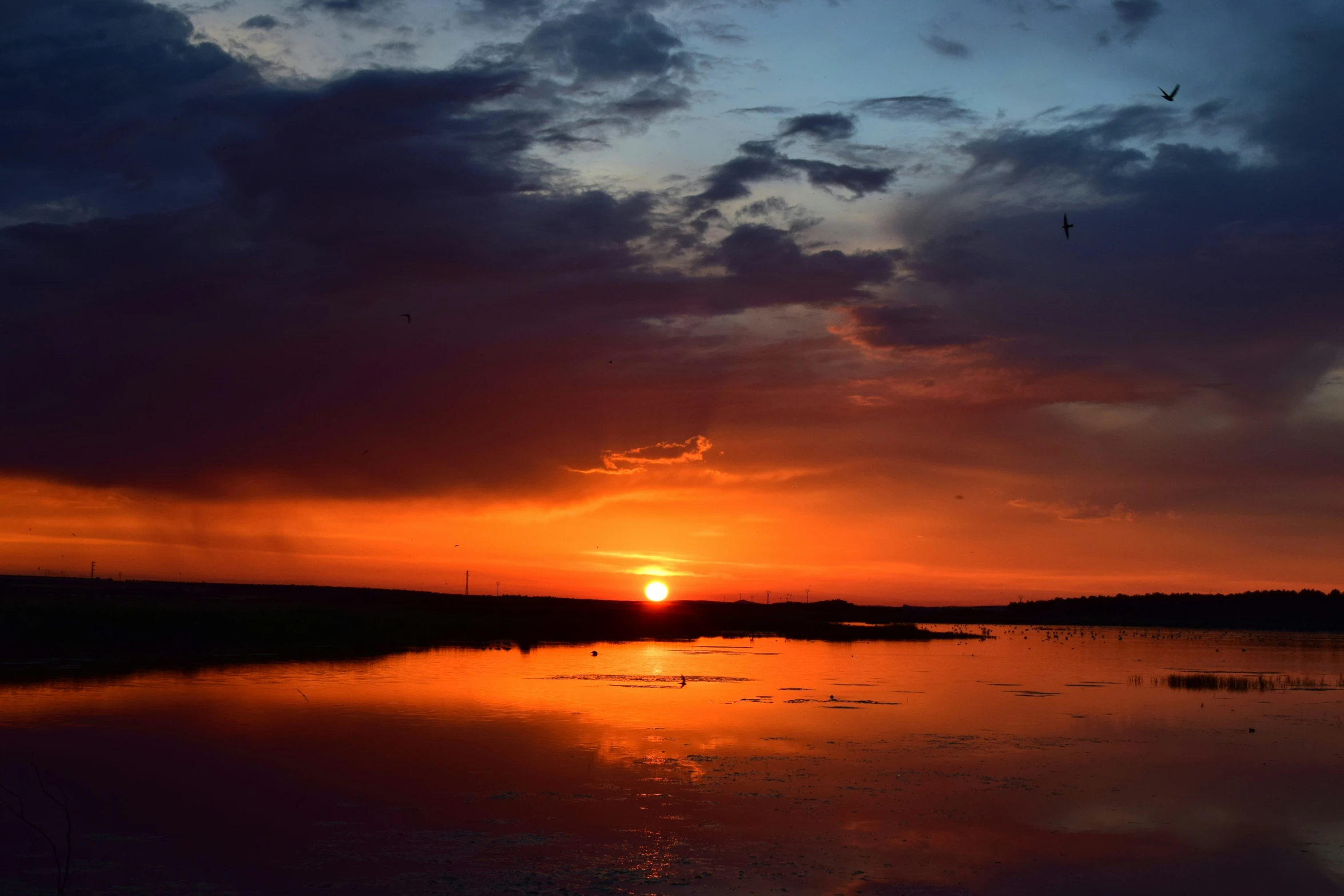 a beautiful sunset on the river with clouds in the sky