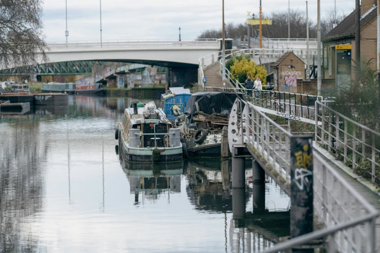 a canal with small boats and a bridge