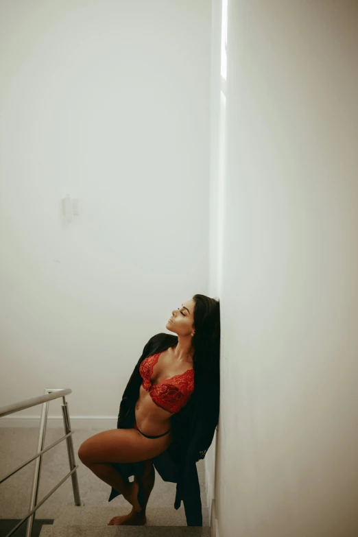 woman in  and red  in corner of stairwell
