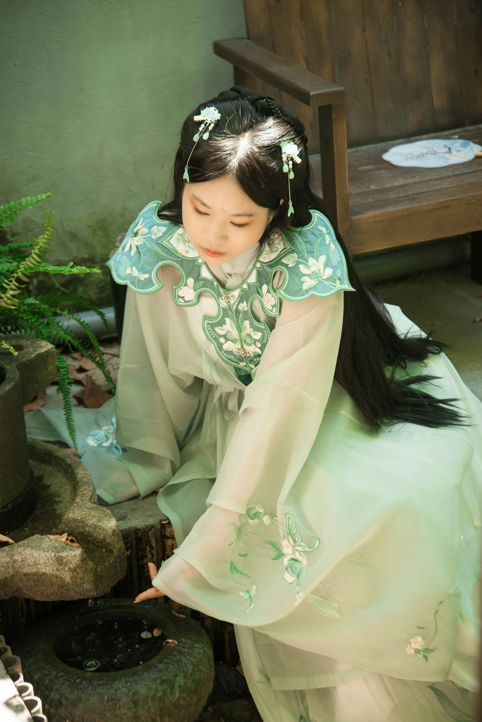 a woman in a green dress sitting on the ground