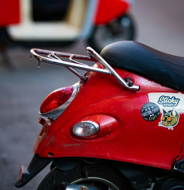 a red scooter with the handlebars down and stickers on