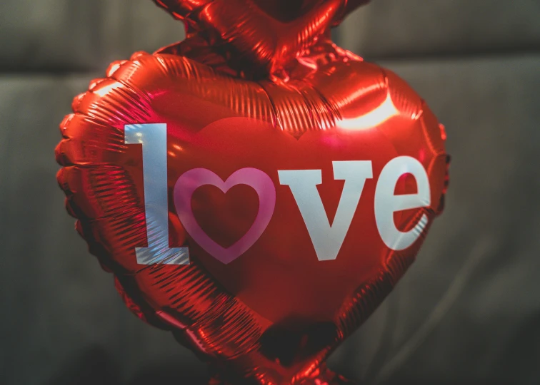 this balloon has the words love on it and is attached to a string