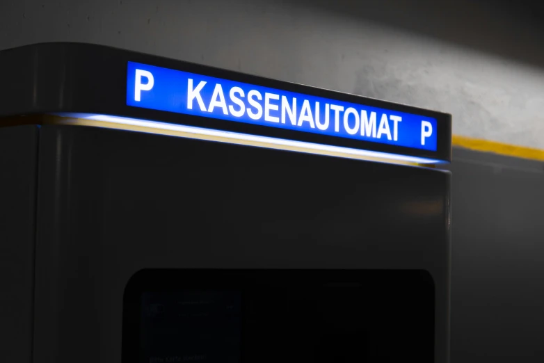 a blue sign reading kassenautumat p above a black and yellow sign