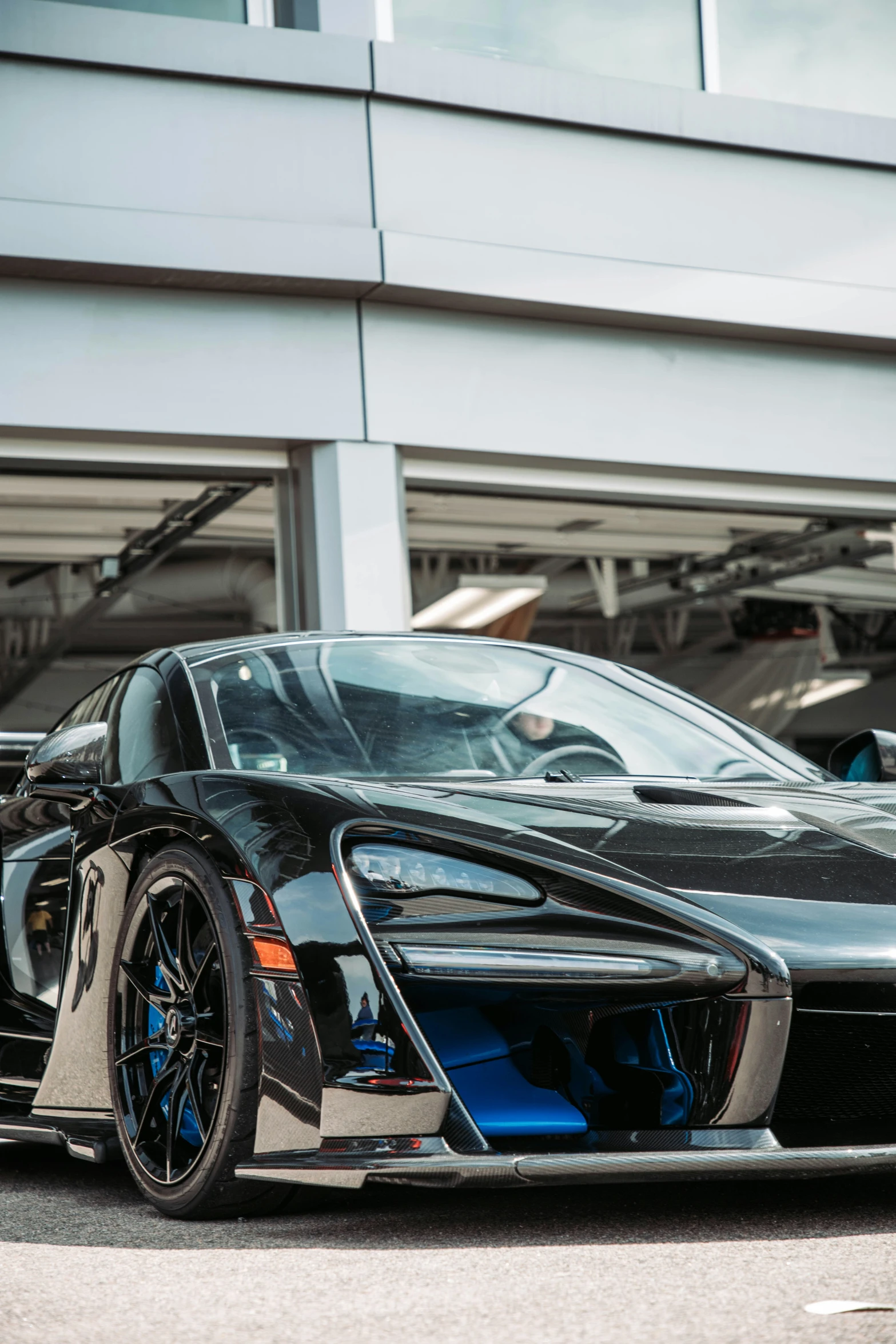 a black, blue and white bugatti sports car is parked next to a building