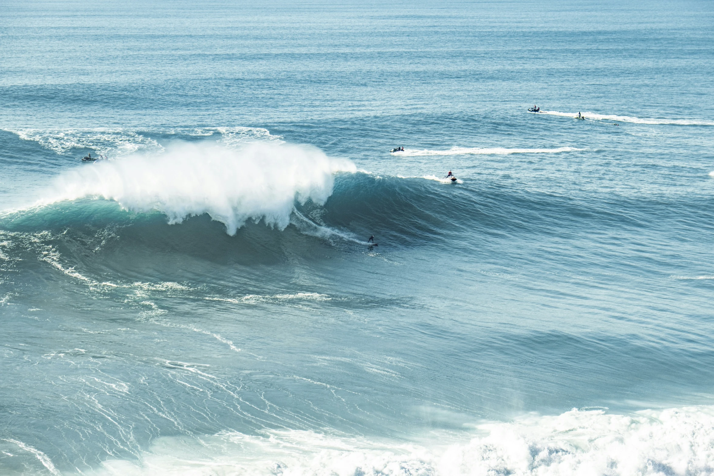 three people surfing on the waves in the ocean