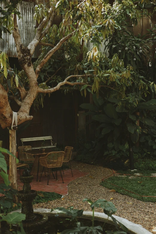 there is a small, wooden deck area with tables and chairs and bushes in the background