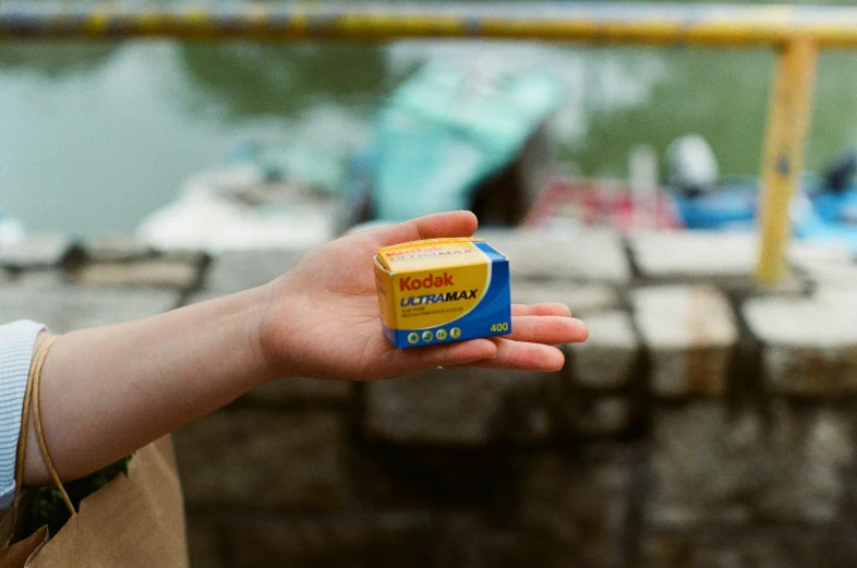 a woman holding a box of food next to a body of water