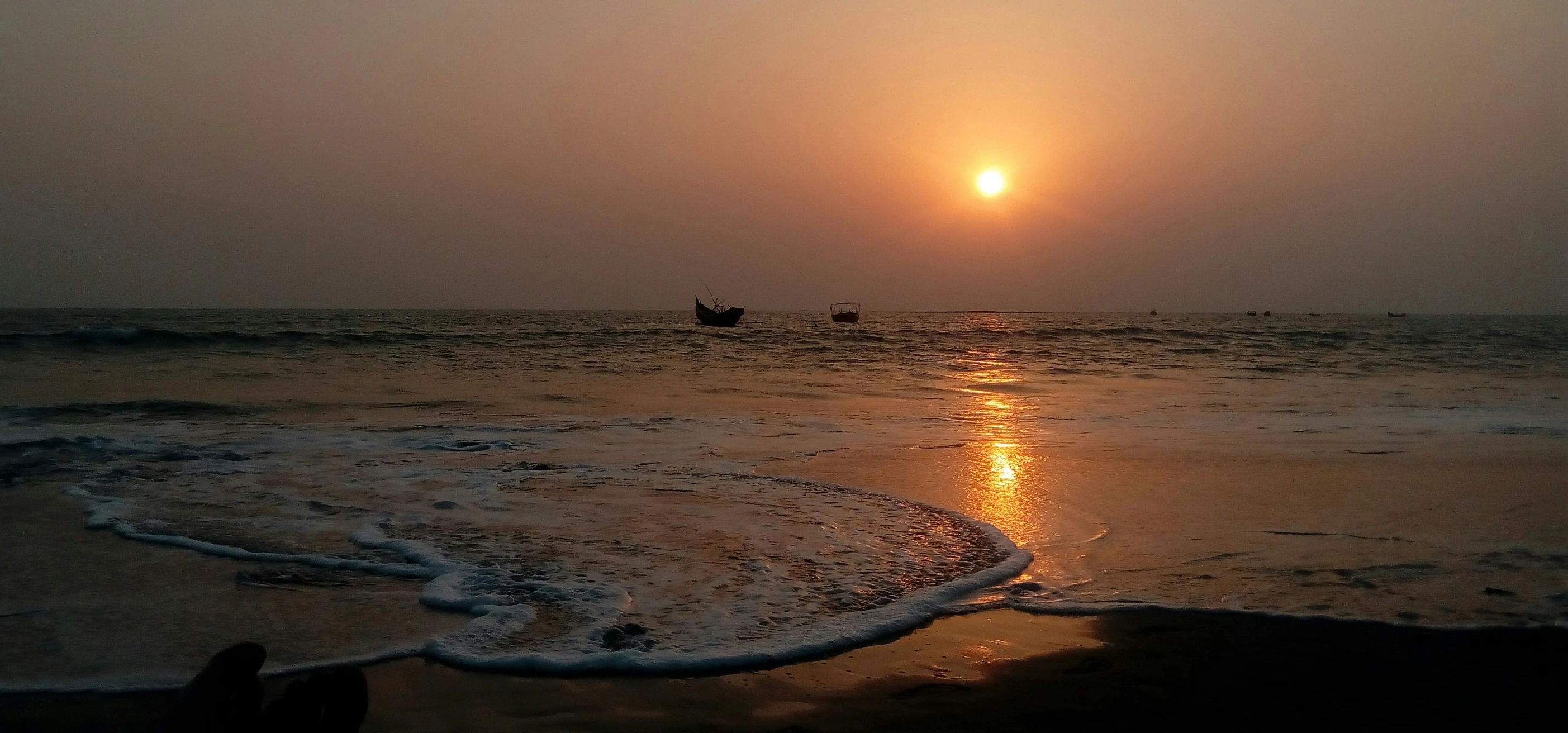 people in a small boat at the edge of the ocean