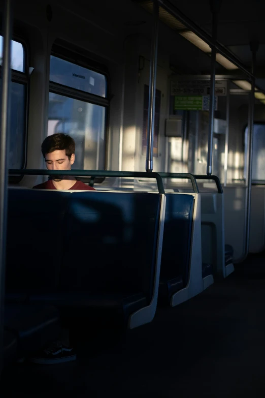 man staring out the window on a city train