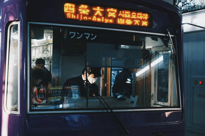 an asian bus with windows is parked near a building