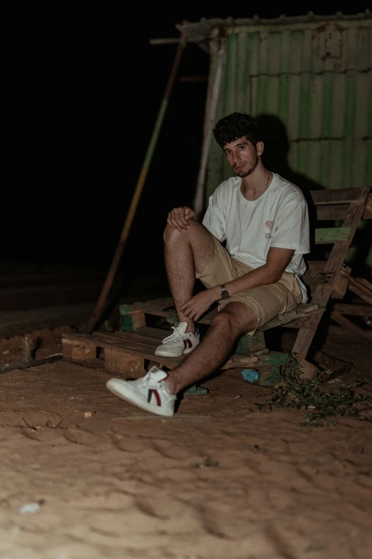 a young man sitting on top of a wooden chair