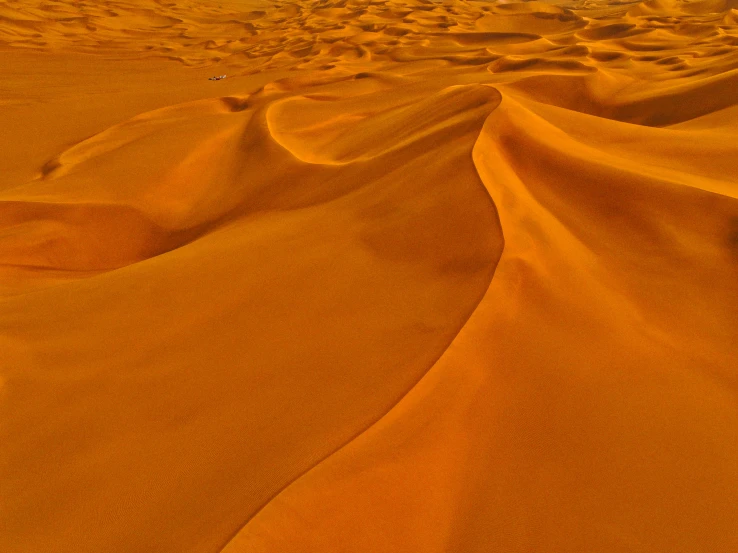 the large desert has many ridges and a lone cloud