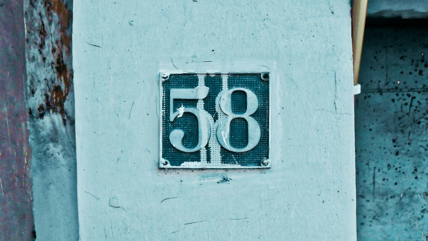 a house number sign mounted to the side of a building