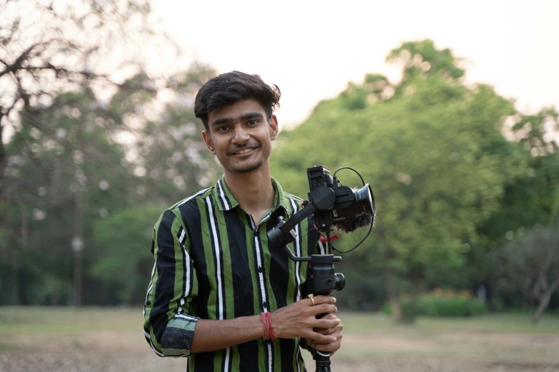 a man standing in the grass holding a camera