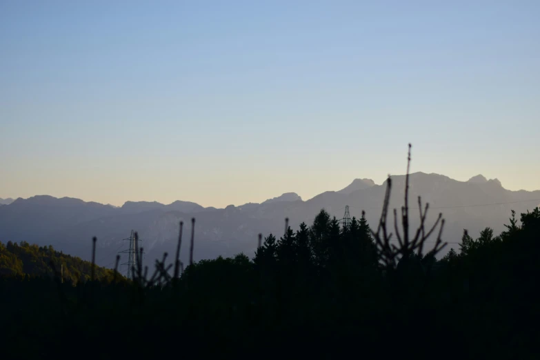 a mountain range is silhouetted against a dark sky