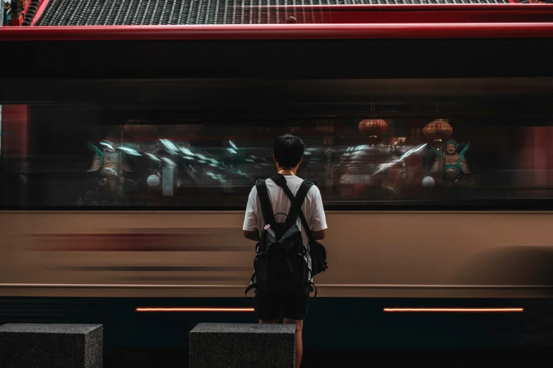 a person standing on a platform looking out the window