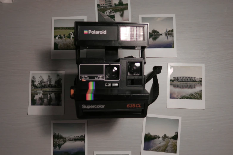 polaroid camera hanging on the wall next to pictures