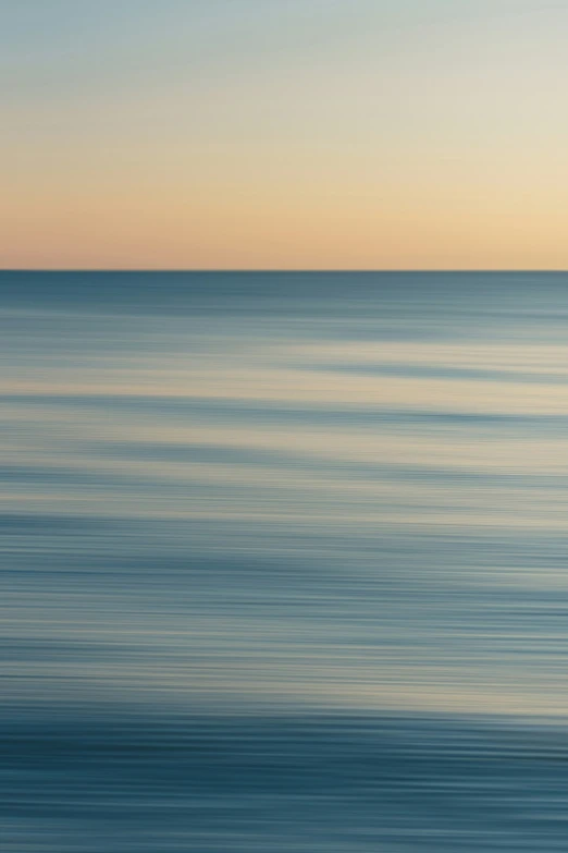 a blue ocean with small ripples and a lone boat